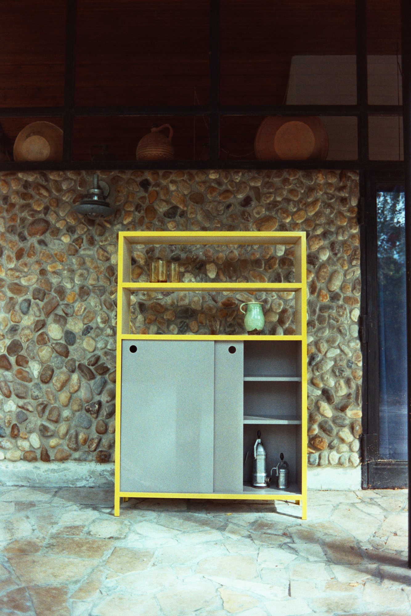Yellow Frame Shelf in a room with a stone wall