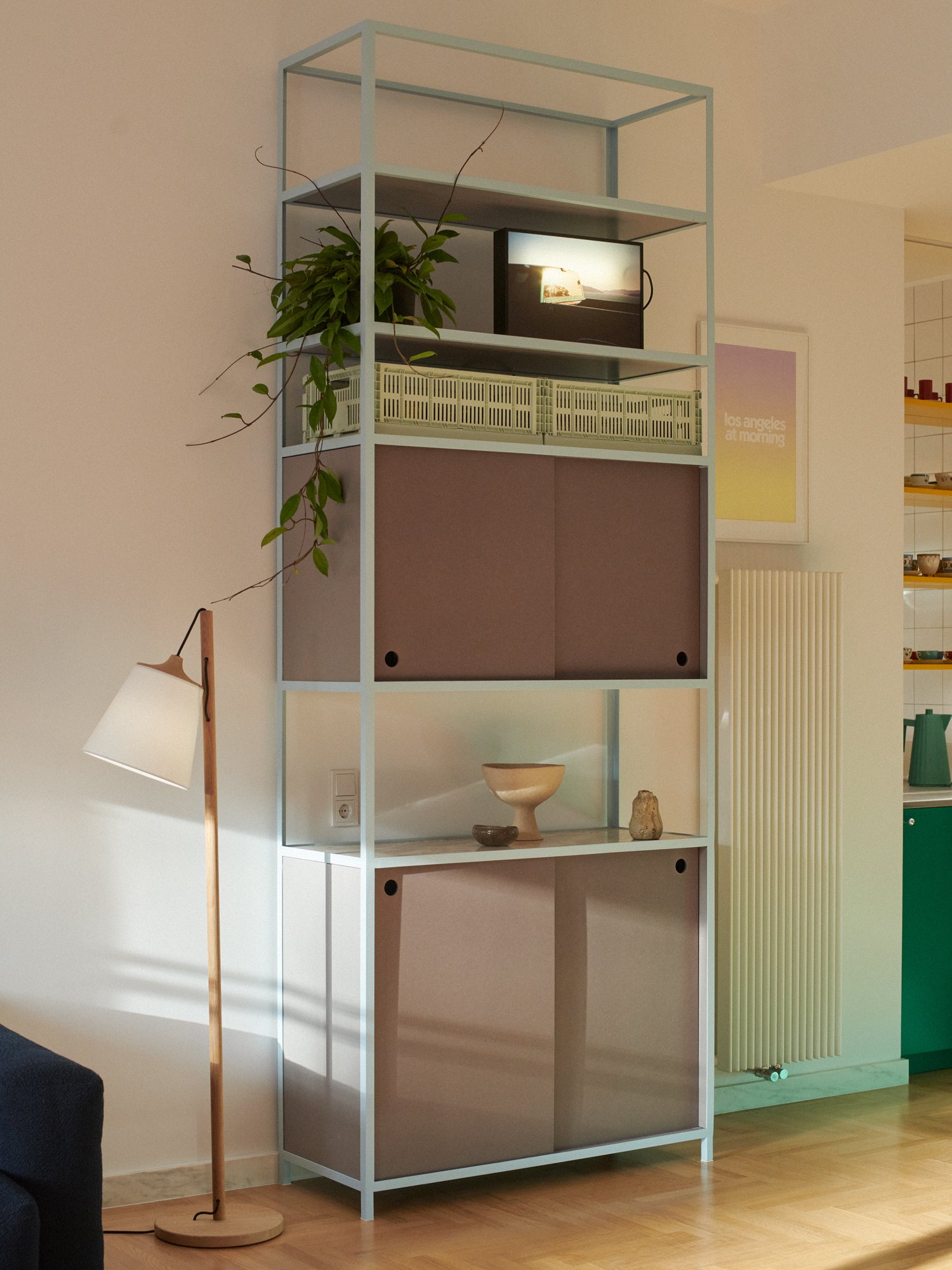 Frame Shelf with a pale blue steel frame and Valchromat sliding doors in a living room