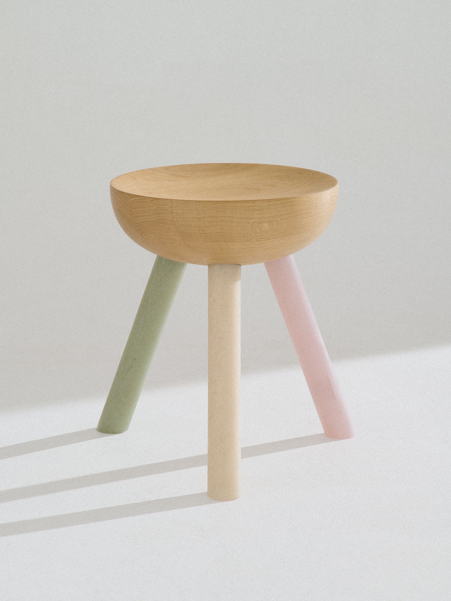 Low NANO Stool with a lathed oak seat on green, natural and pink legs