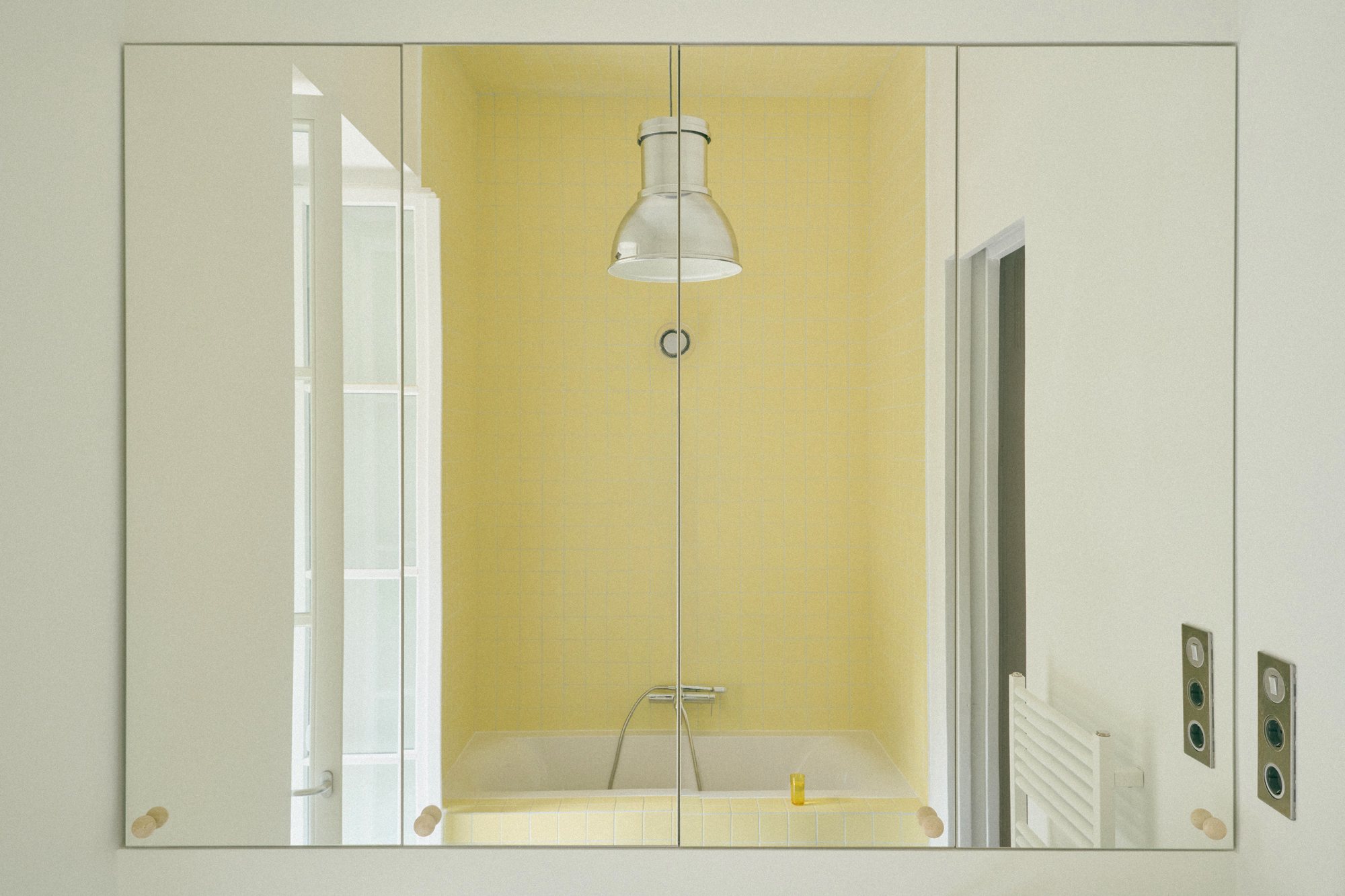 B6 apartment: yellow tiled bathroom cube behind a glass door