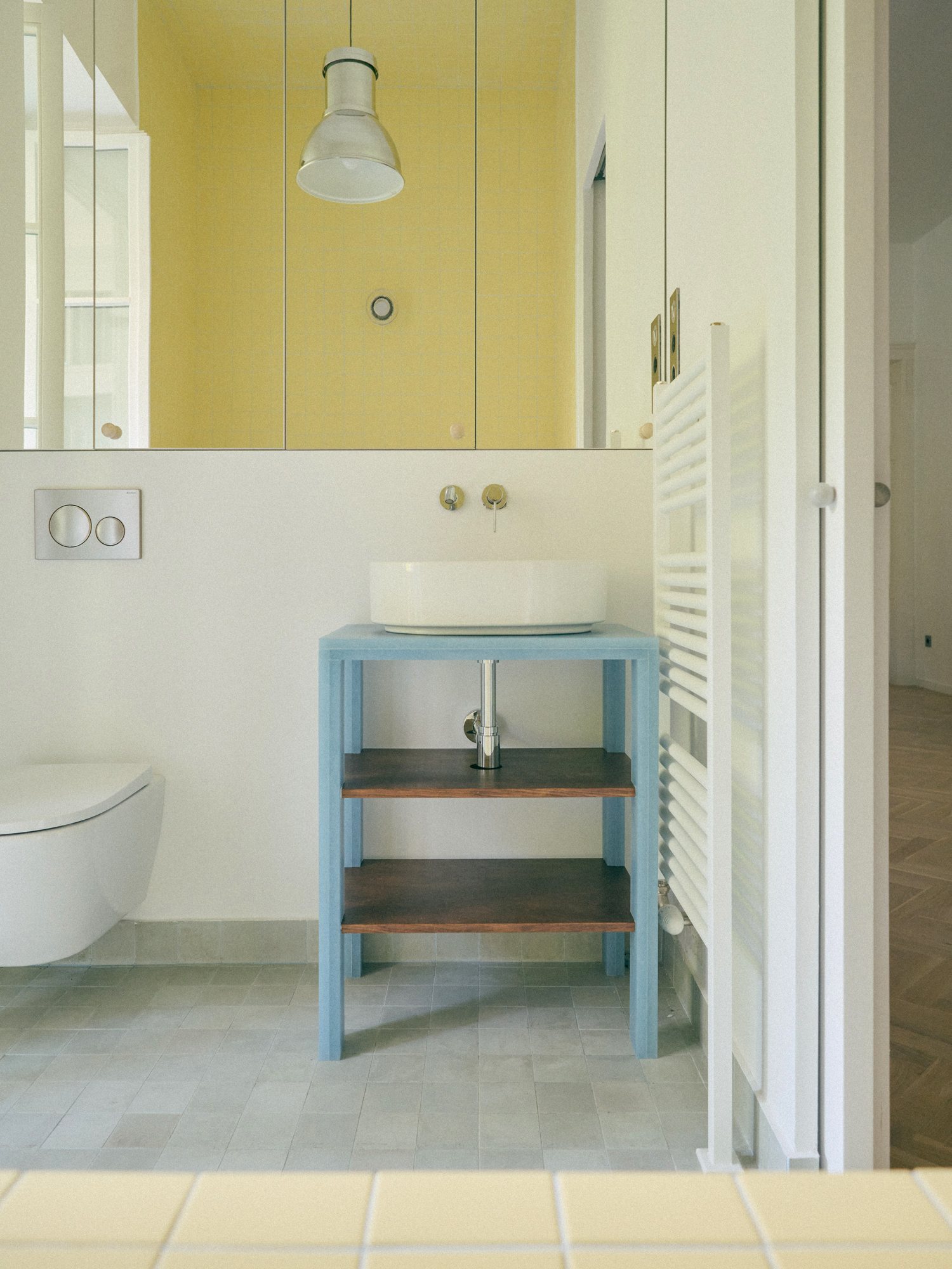 B6 apartment: yellow bathroom with a blue washstand
