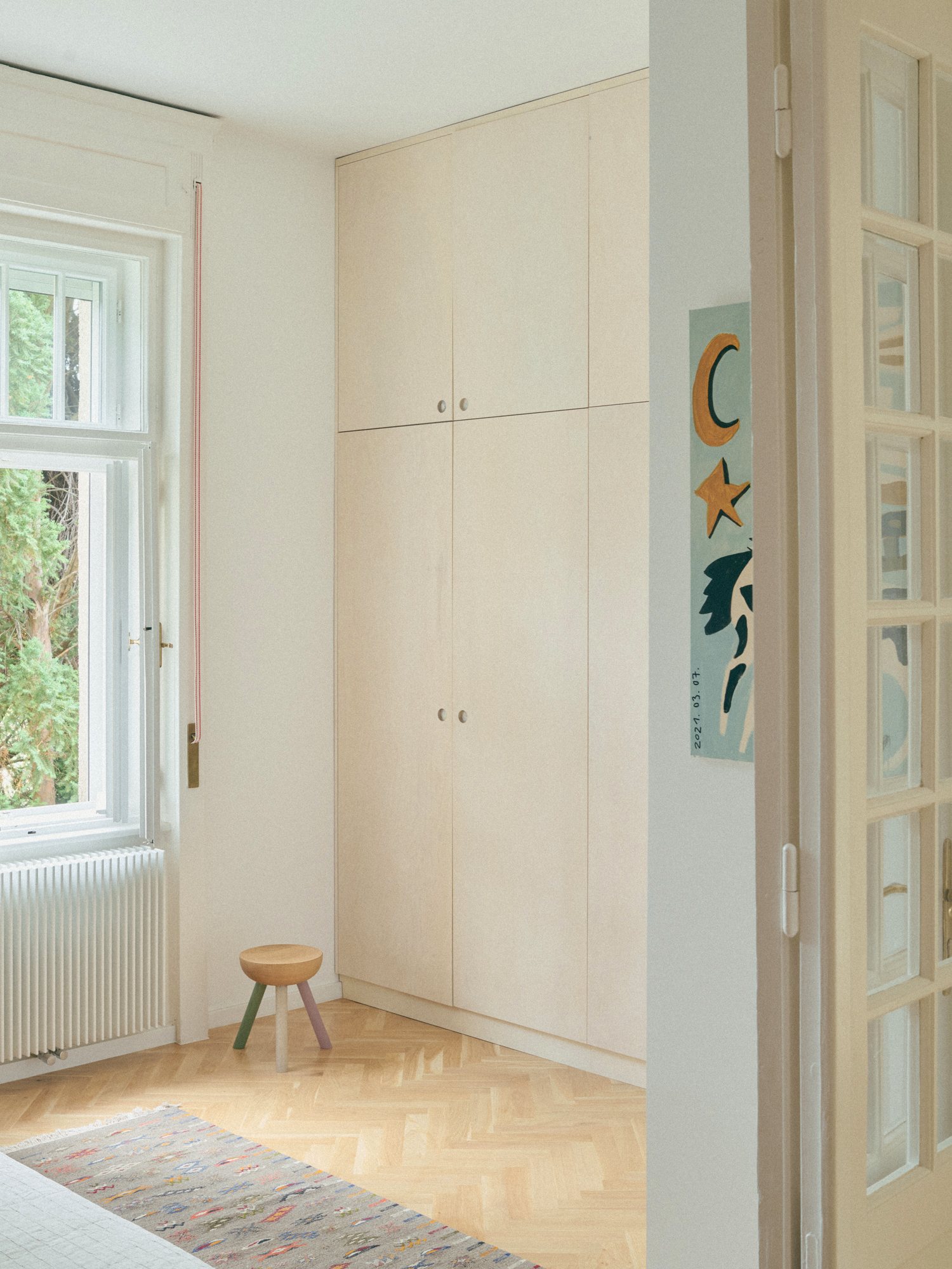 B6 apartment: bright room with a built-in wardrobe and a small stool