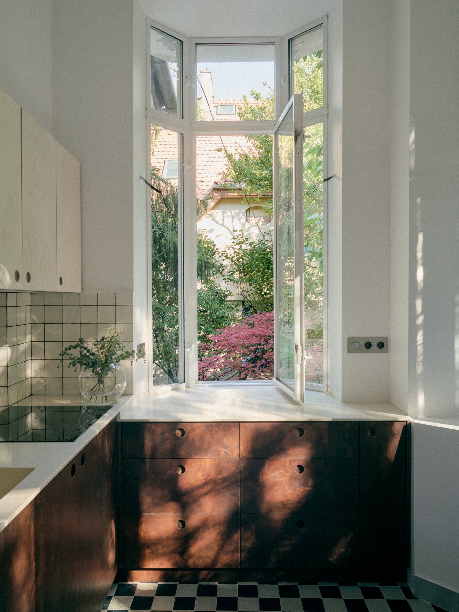 B6 apartment: dark wood kitchen cabinets below a tall garden window