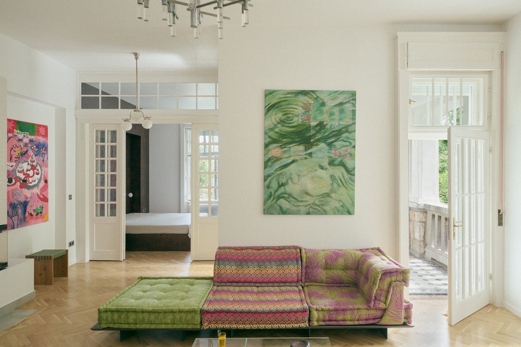 B6 apartment: living room with a patterned sofa and colourful artworks