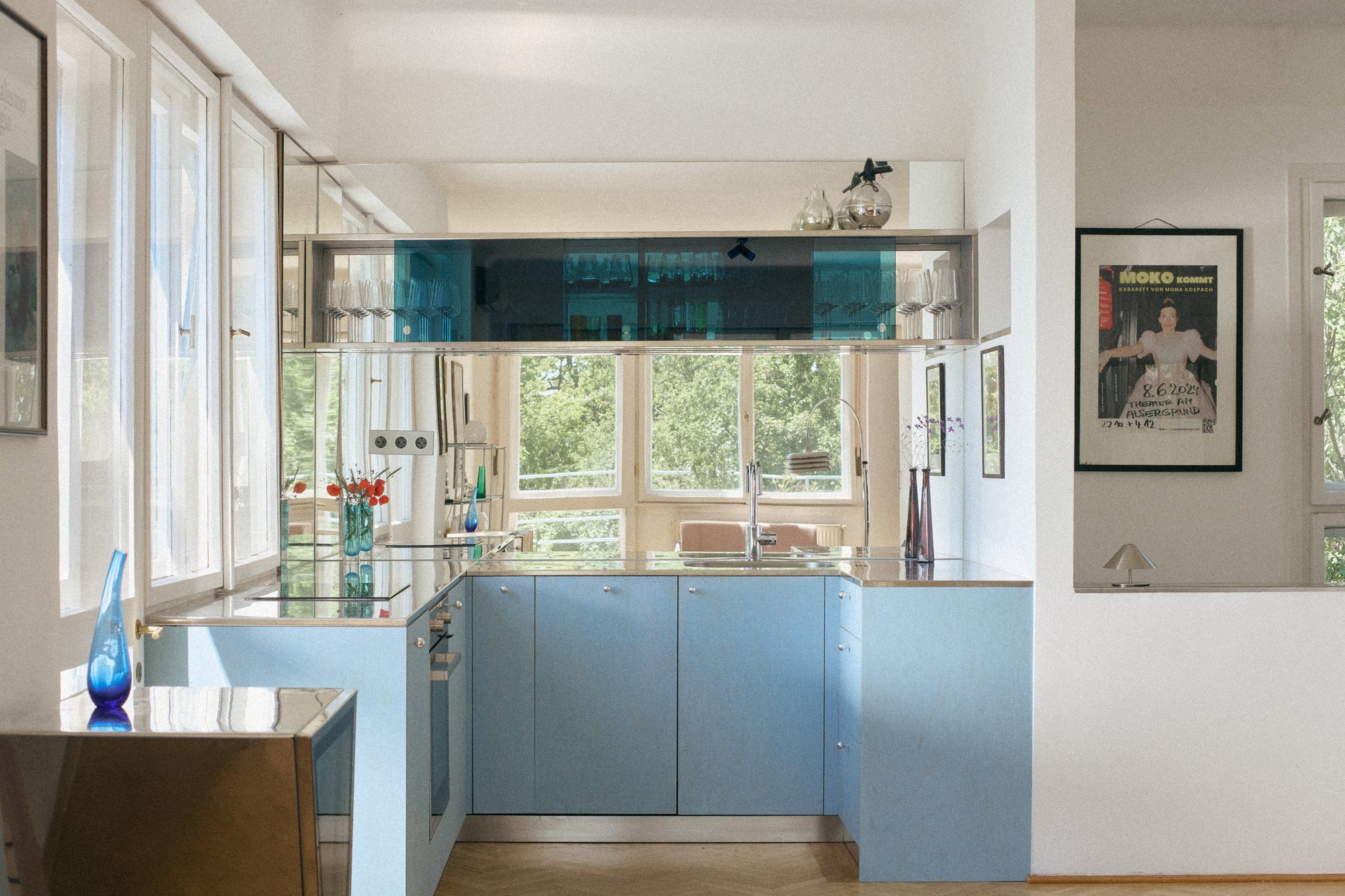 B75 kitchen: powder-blue cabinetry below a floating blue glass cabinet