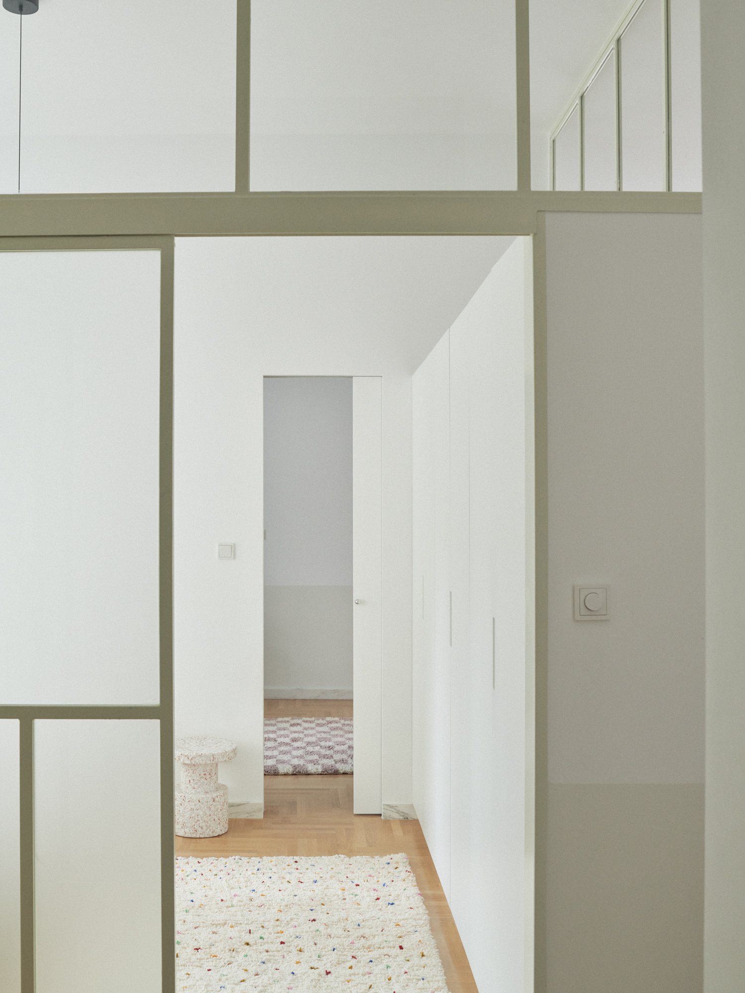E6 apartment: white hallway with glazed partitions to the bedrooms