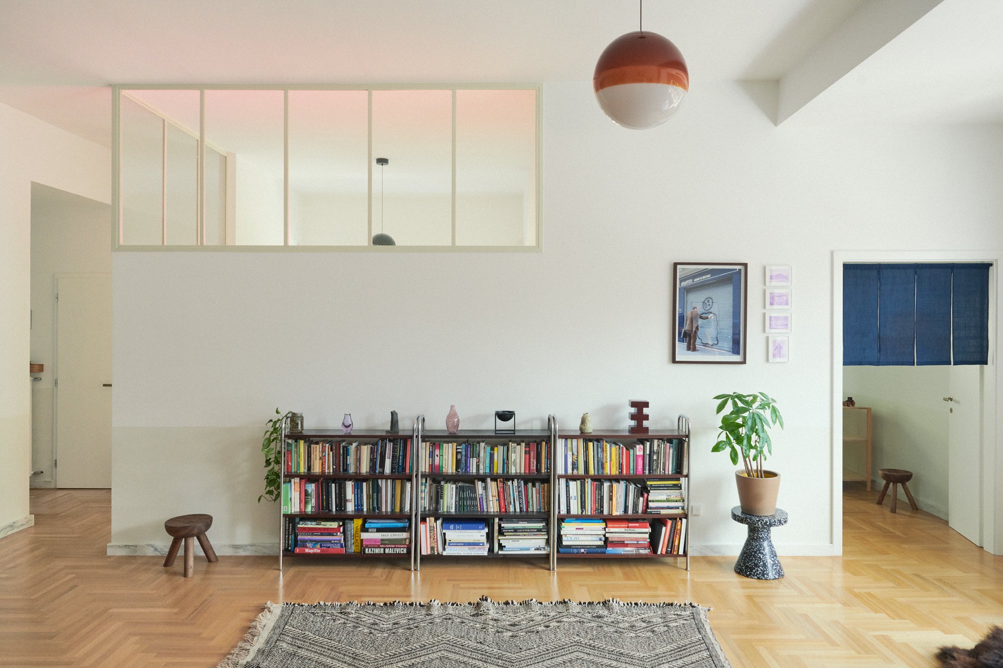 E6 apartment: low bookshelf below a glazed interior window