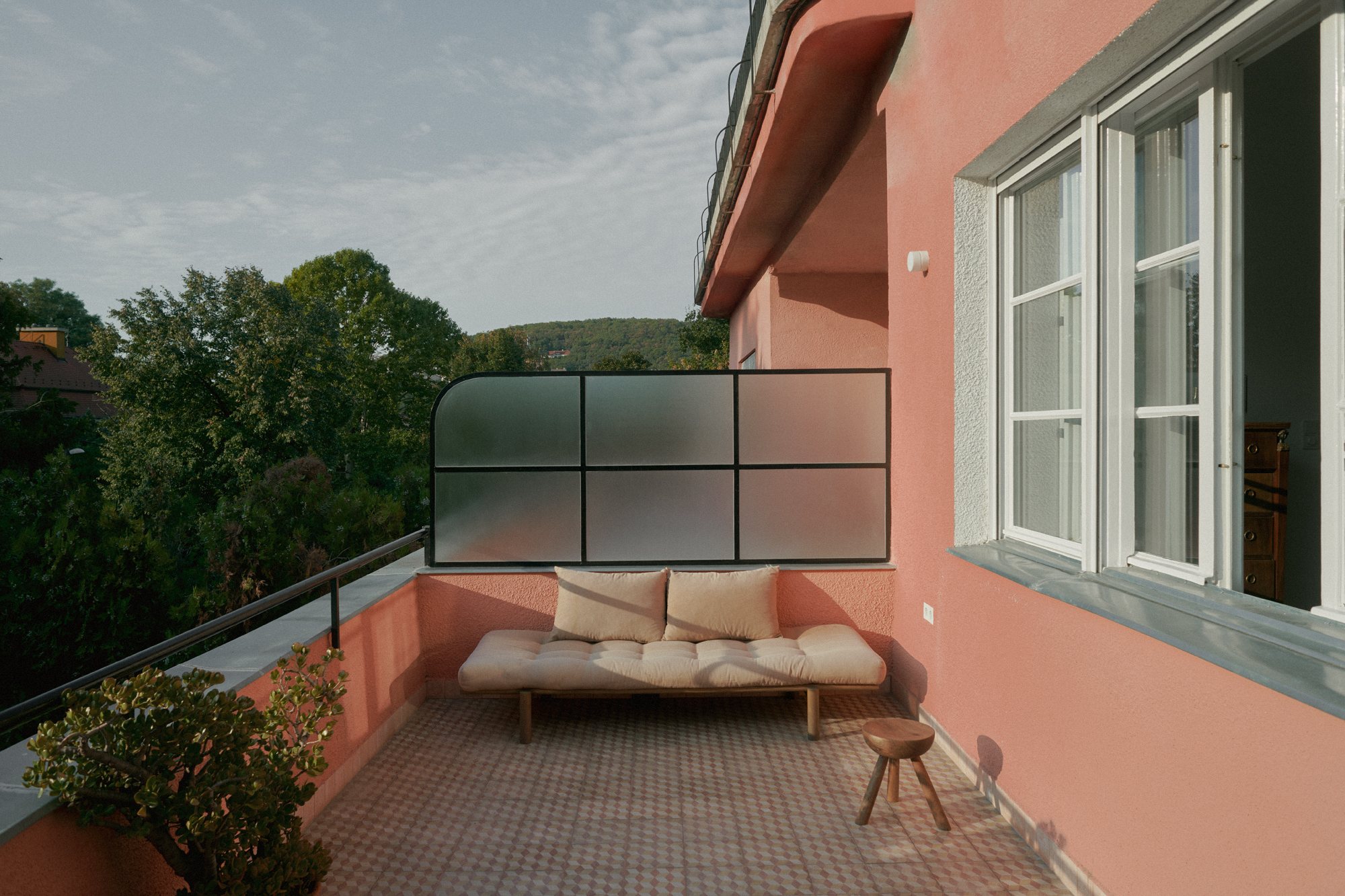 E6 apartment: terrace along the coral facade of the villa