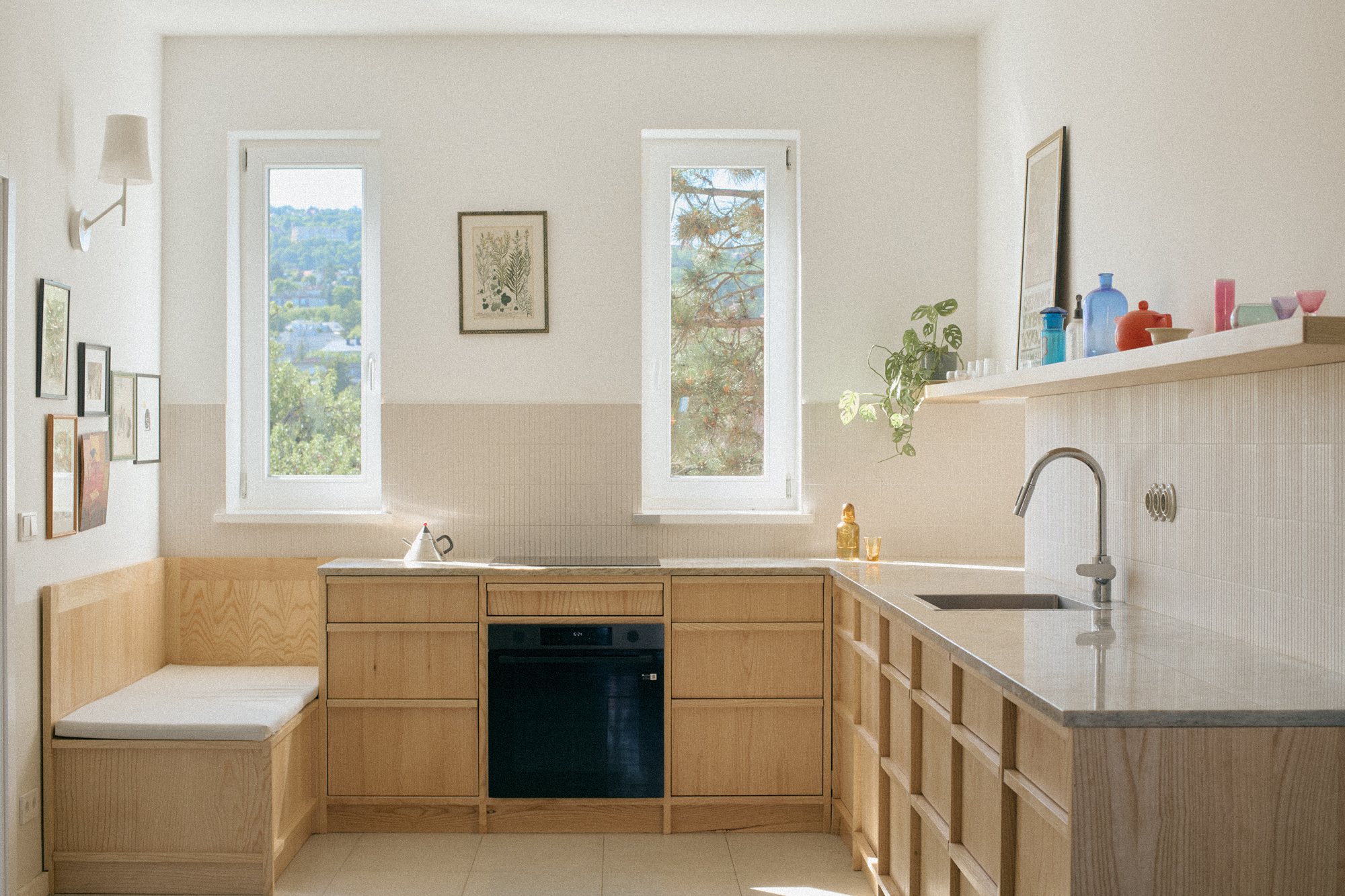 N6 kitchen: ash wood cabinetry, a built-in bench and a black oven