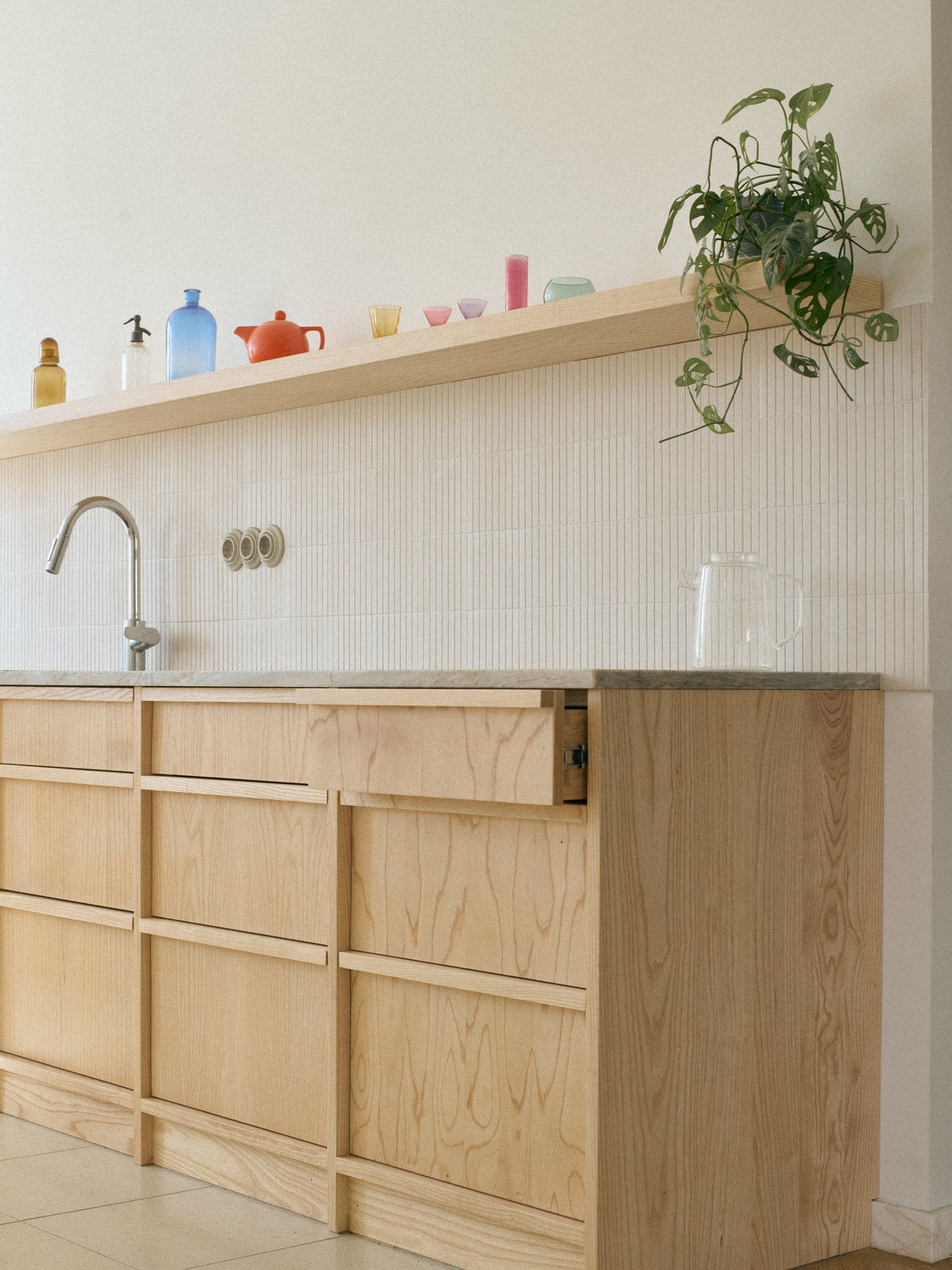 N6 kitchen: textured backsplash and granite worktop below the shelf