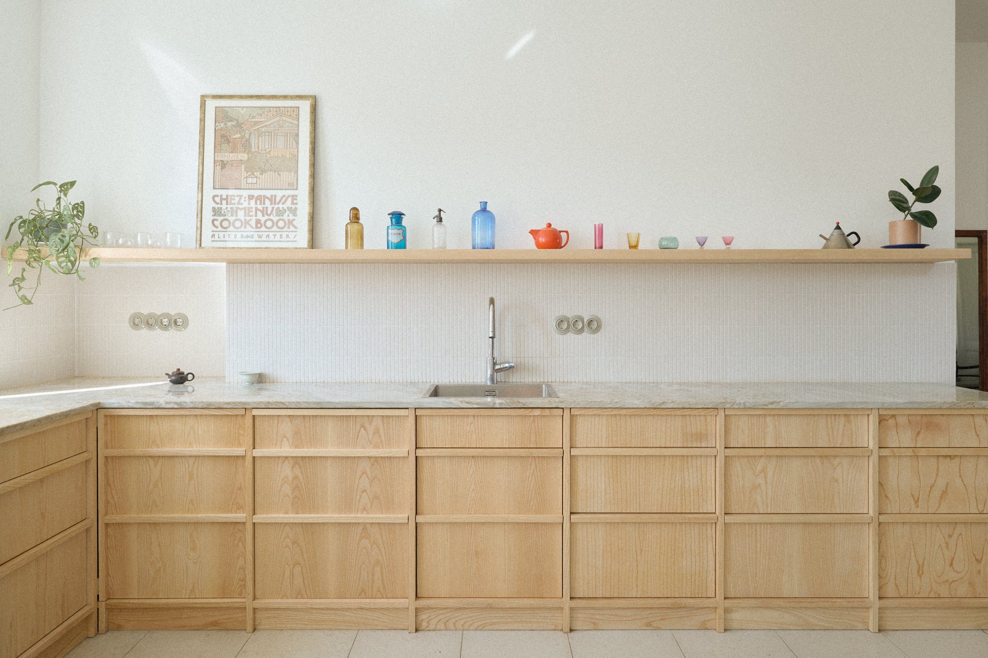 N6 kitchen: lacquered ash cabinetry below an uninterrupted shelf of colourful objects